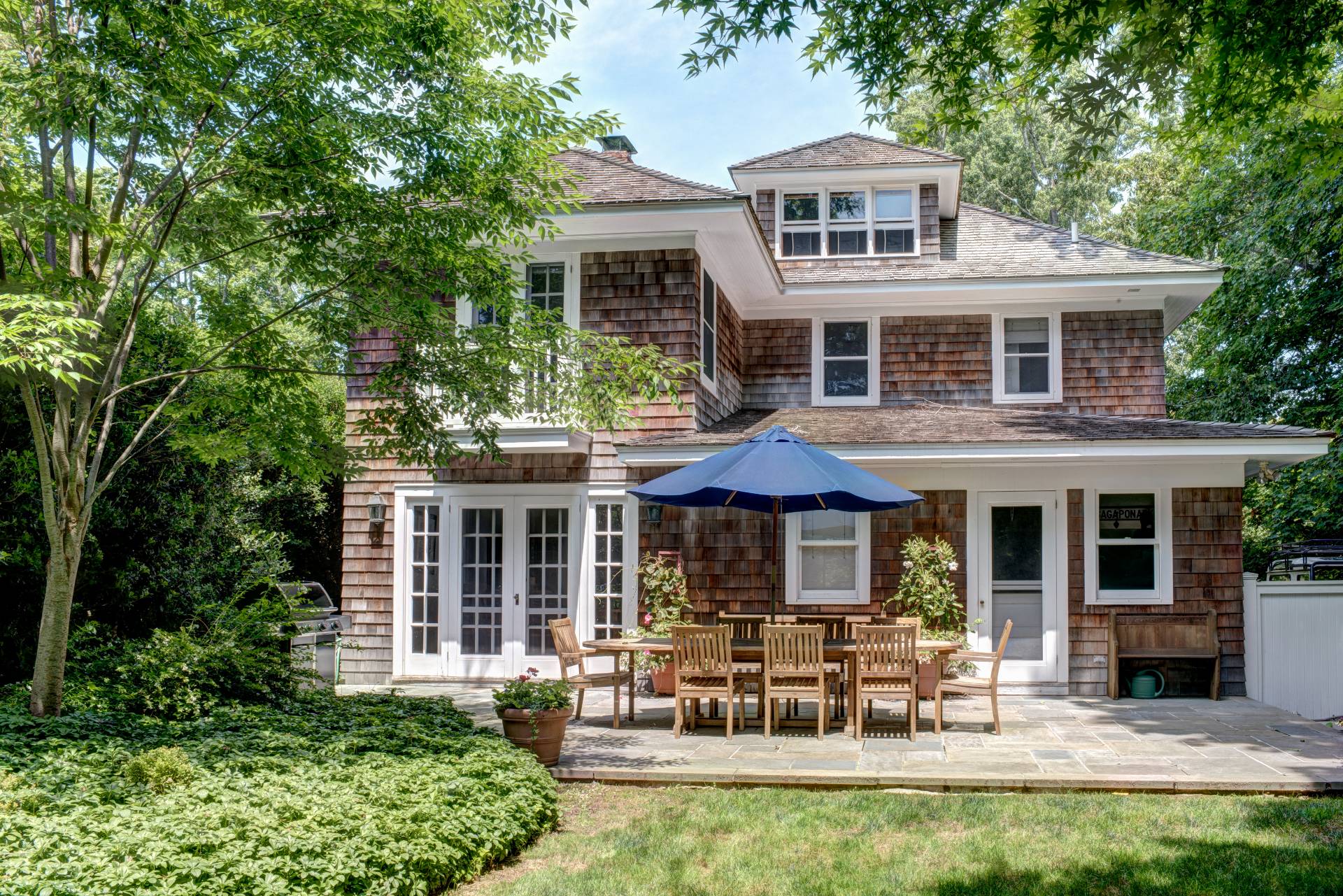 151 Church Lane Bridgehampton, NY 11932 - Photo 1 of 20 a front view of a house with a yard table and chairs