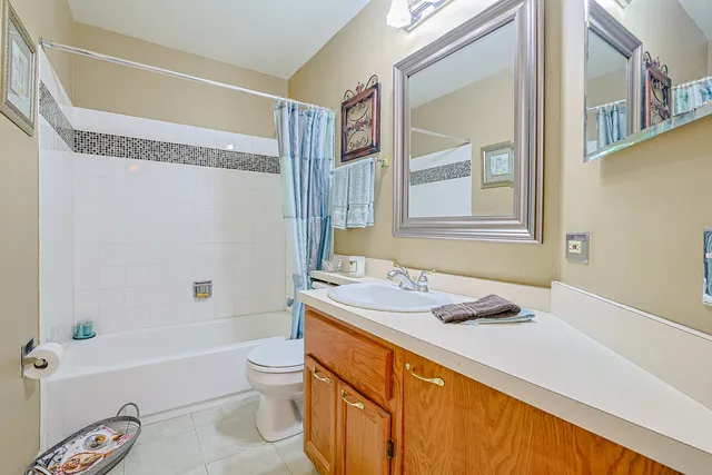 a bathroom with a granite countertop sink a toilet and shower
