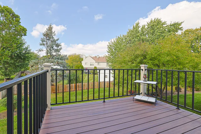 a view of a deck with wooden floor and fence with a large garden