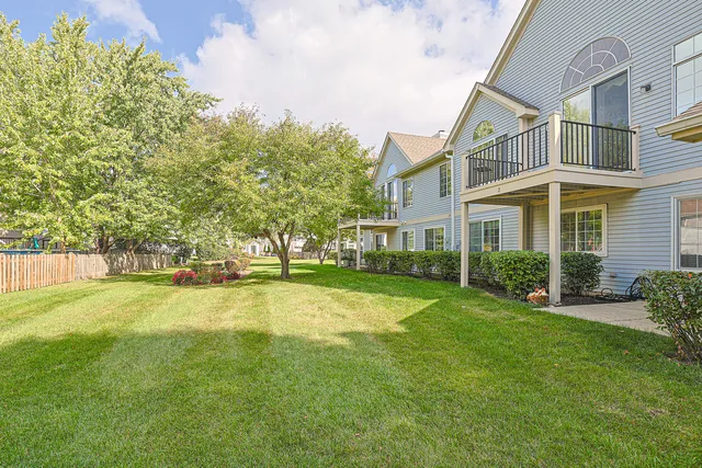 a view of a house with a big yard and potted plants