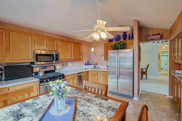 a kitchen with stainless steel appliances granite countertop a refrigerator a stove top oven a sink and dishwasher