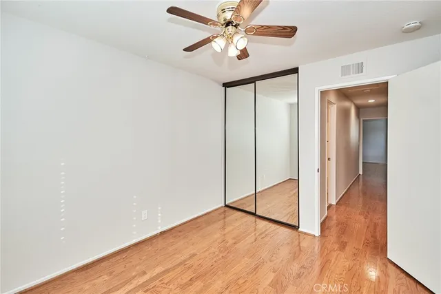 an empty room with a window and a fan
