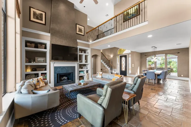 a living room with furniture a fireplace and a large window