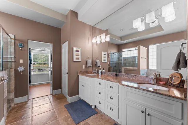 a spacious bathroom with a double vanity sink a mirror and shower