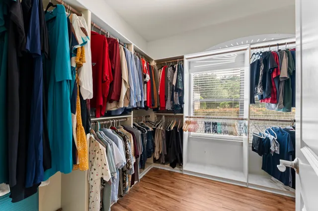 a view of walk in closet with clothes and shoes