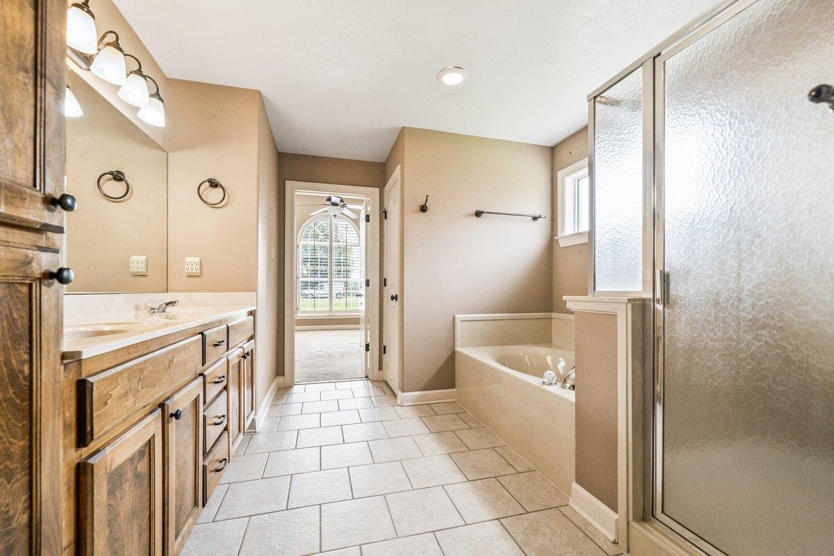 583 Rosemark Road Atoka, TN 38004 - Photo 16 of 25 a bathroom with a tub a sink a mirror and a shower