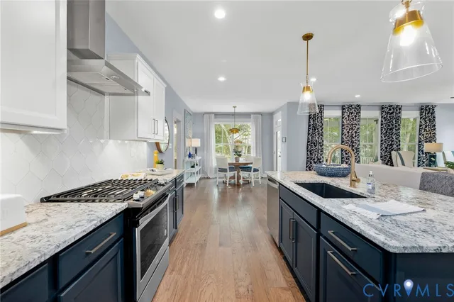 a kitchen with granite countertop a sink stove and cabinets