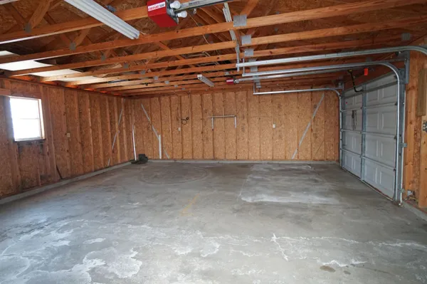 a view of empty room with wooden floor fan and window