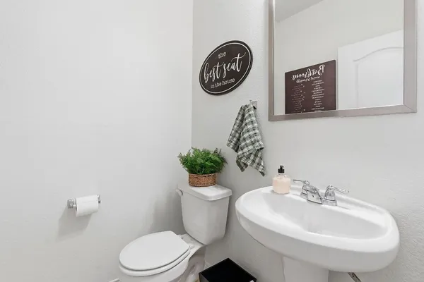 a bathroom with a toilet a sink and a mirror