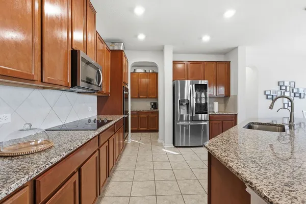 a kitchen with stainless steel appliances granite countertop a sink stove and refrigerator