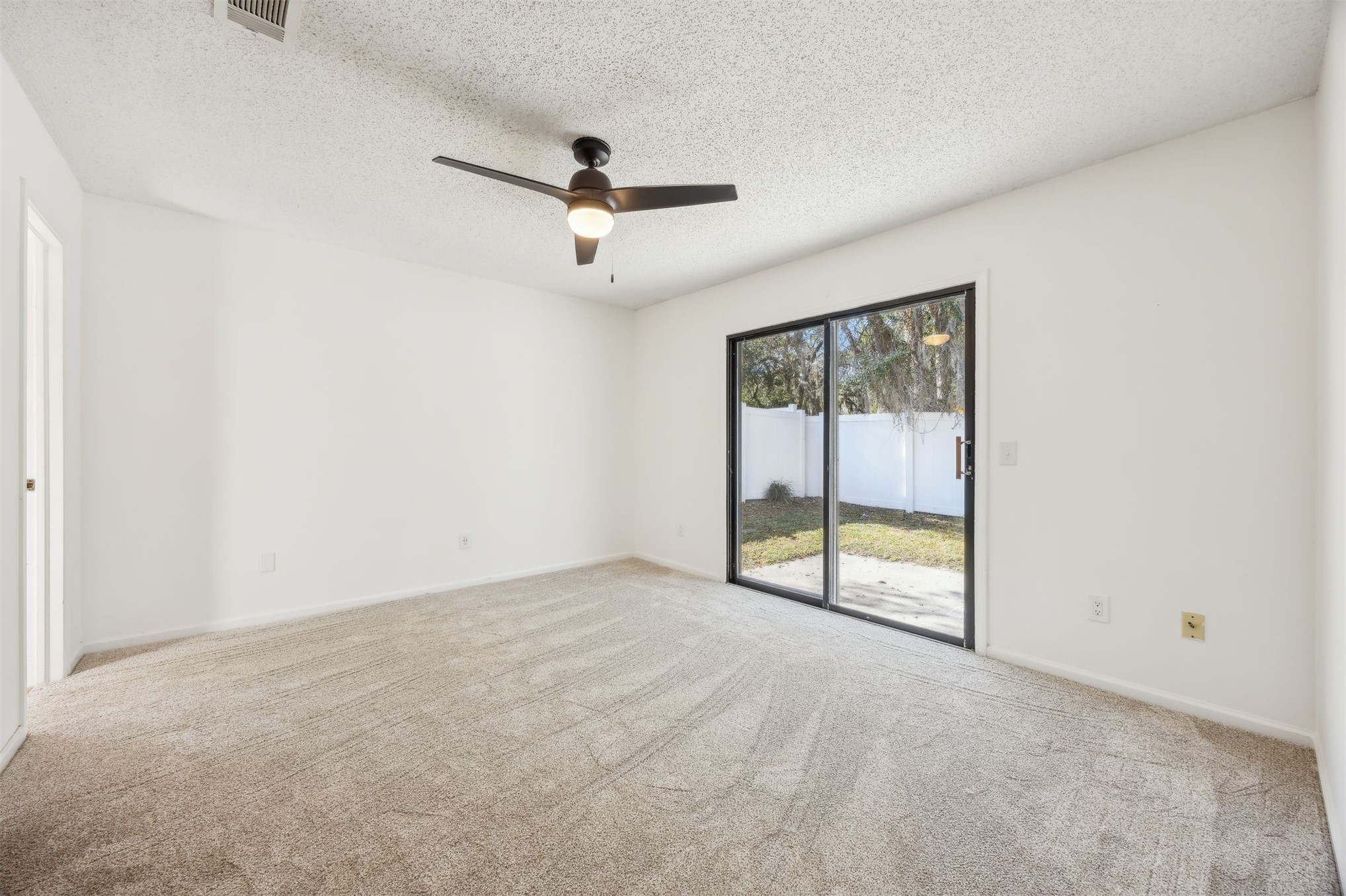 7 Jasmine Place Fernandina Beach, FL 32034 - Photo 9 of 27 an empty room with a ceiling fan and a window