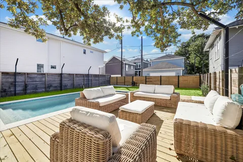 a view of a backyard with couches table and chairs and wooden fence