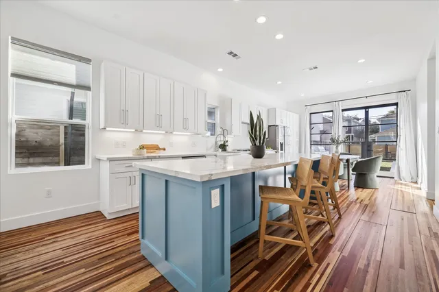 a open kitchen with wooden floor and white cabinets