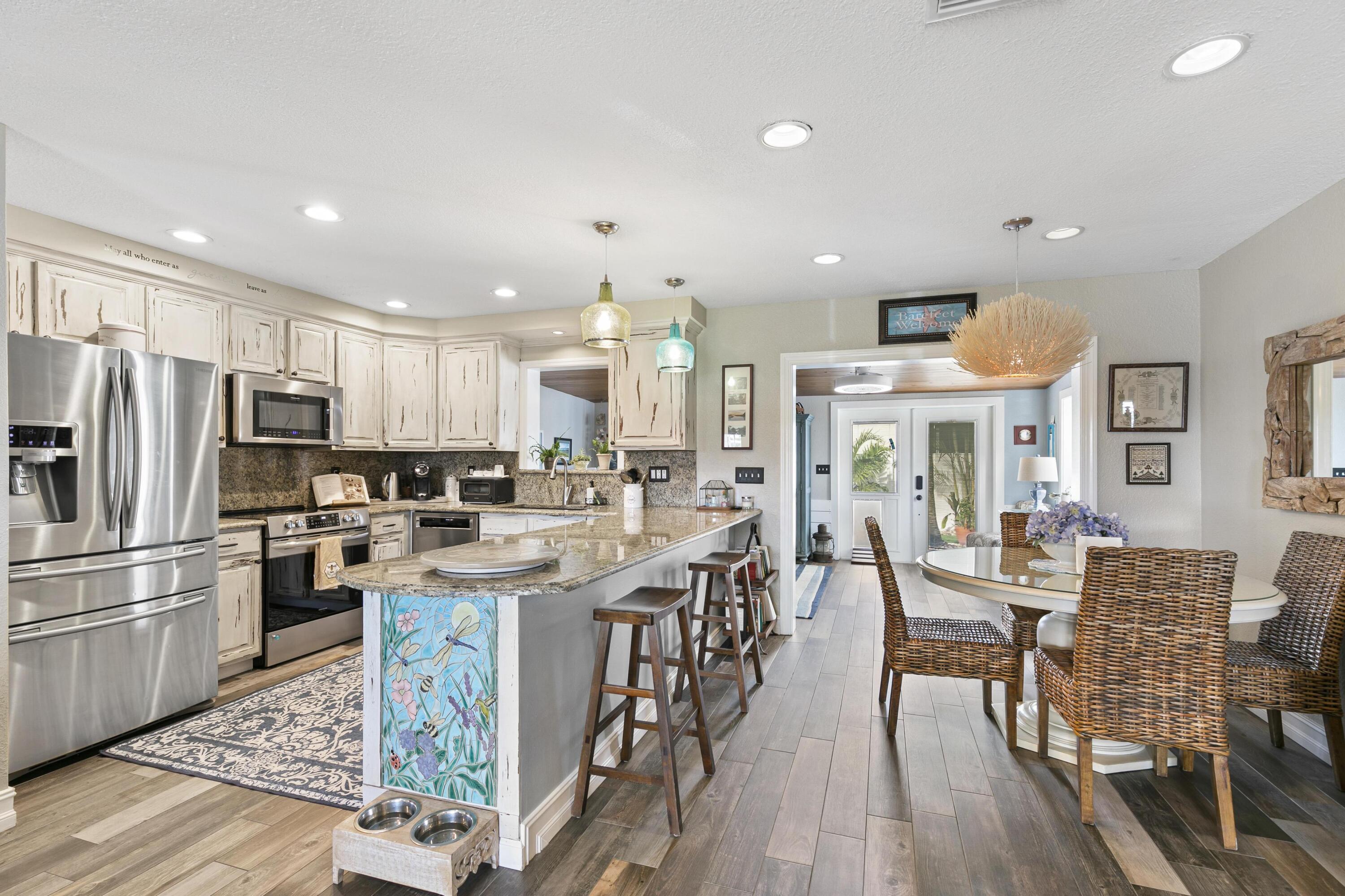 9025 Pomelo Road West Fort Myers, FL 33967 - Photo 5 of 27 a kitchen with stainless steel appliances granite countertop a table chairs refrigerator and sink