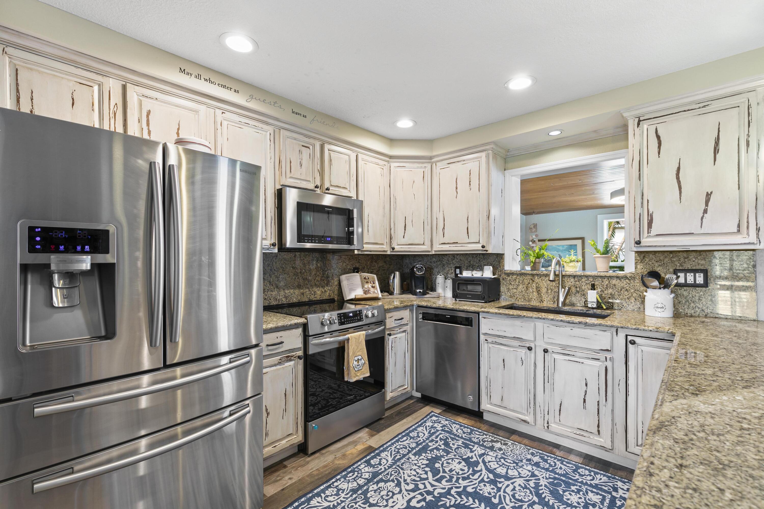 9025 Pomelo Road West Fort Myers, FL 33967 - Photo 6 of 27 a kitchen with stainless steel appliances granite countertop a refrigerator sink and stove