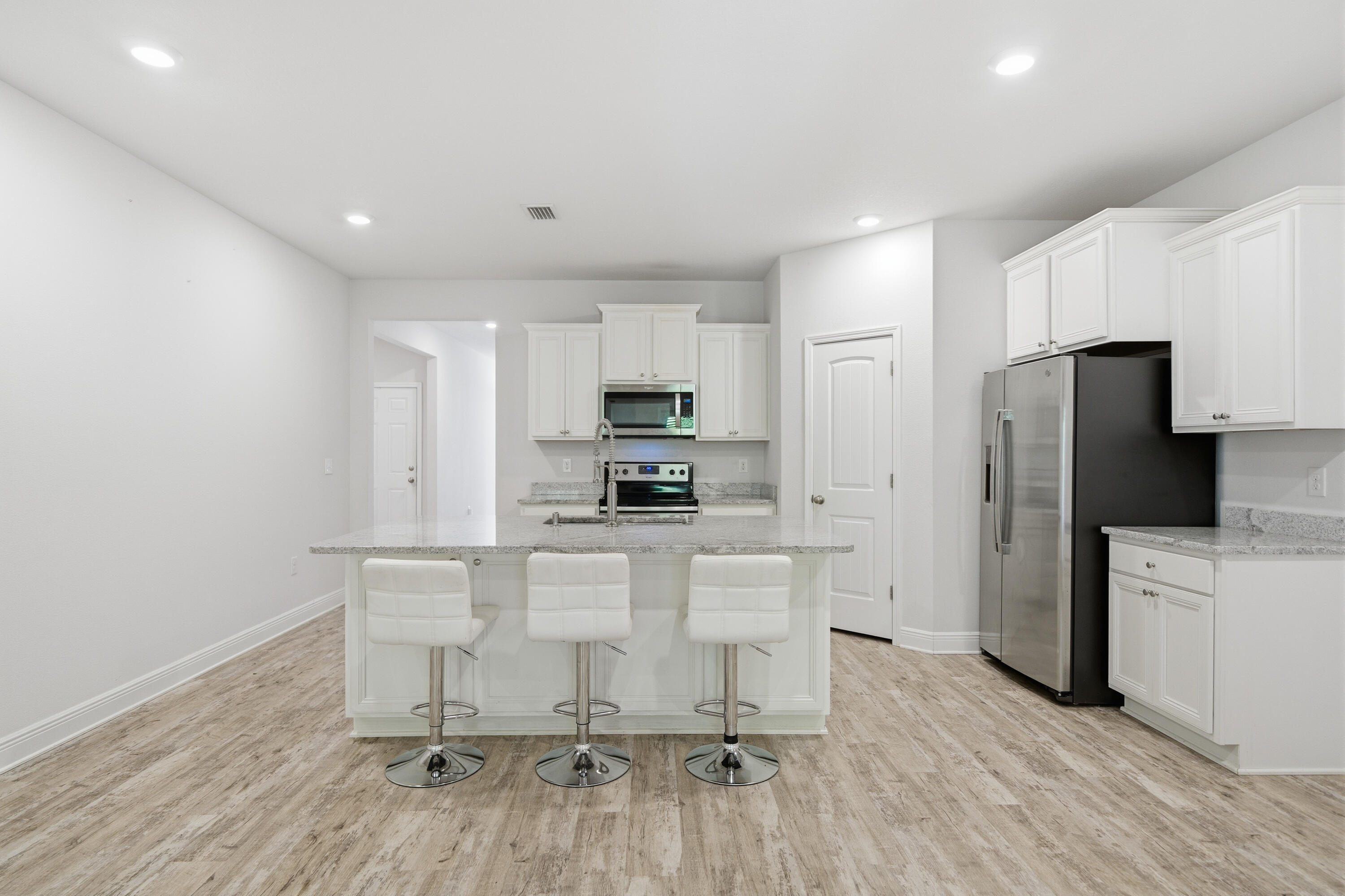 191 Southern Pnes Road Santa Rosa Beach, FL 32459 - Photo 11 of 46 a kitchen with a refrigerator a white cabinets and wooden floor