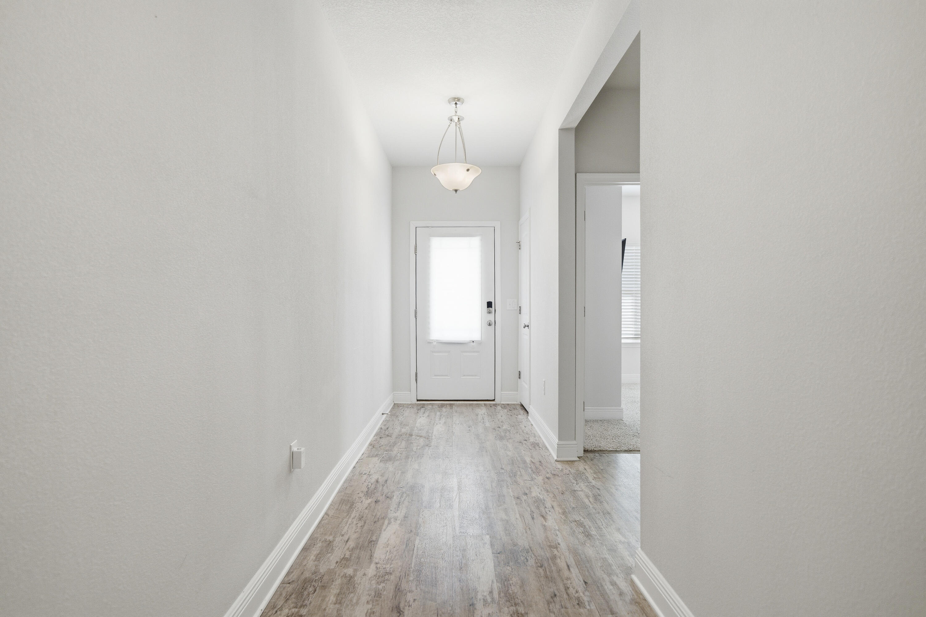 191 Southern Pnes Road Santa Rosa Beach, FL 32459 - Photo 30 of 46 a view of a hallway with wooden floor and a bathroom