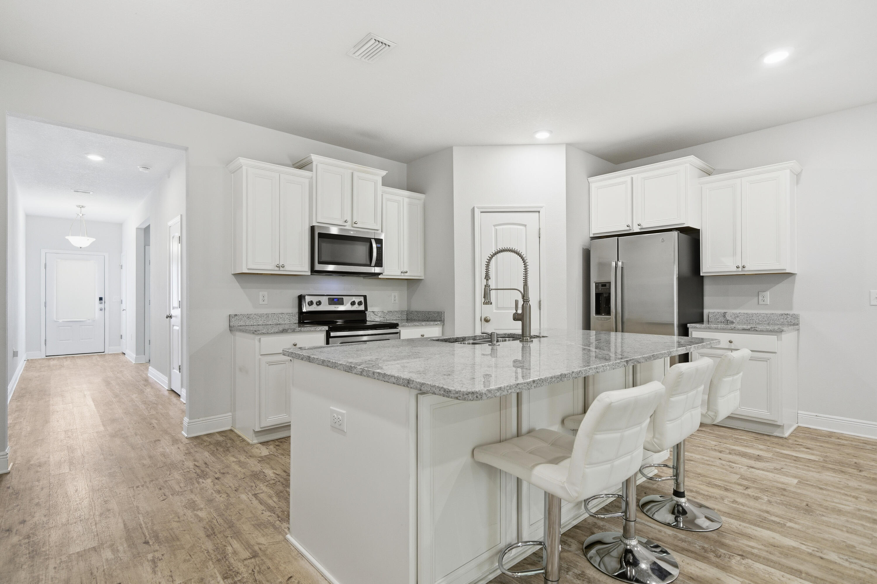 191 Southern Pnes Road Santa Rosa Beach, FL 32459 - Photo 9 of 46 a kitchen with stainless steel appliances granite countertop a stove top oven a sink a refrigerator white cabinets and wooden floor