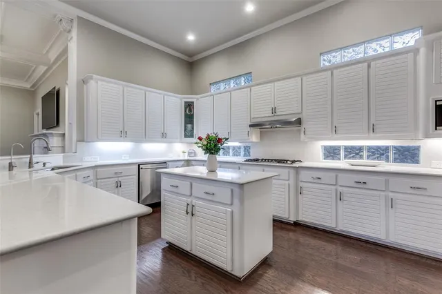 a kitchen with white cabinets and sink