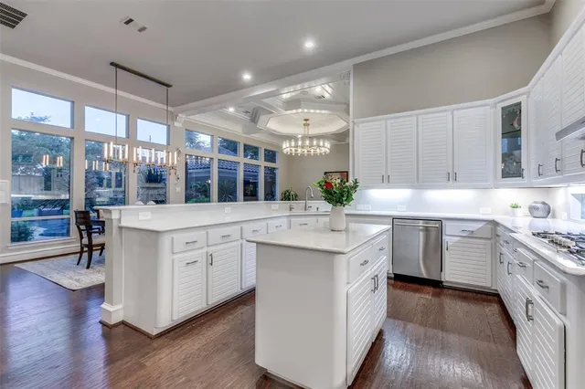 a kitchen with stainless steel appliances kitchen island granite countertop a stove and a sink