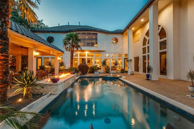 a living room with lots of furniture kitchen view and a large window