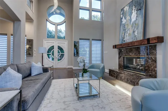 a living room with furniture a fireplace and a large window