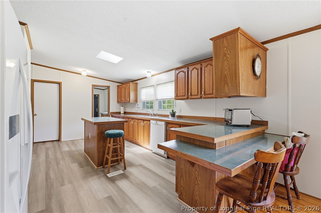 10400 Ruth Vinson Road Autryville, NC 28318 - Photo 27 of 49 a kitchen with a table chairs a sink dishwasher refrigerator and cabinets