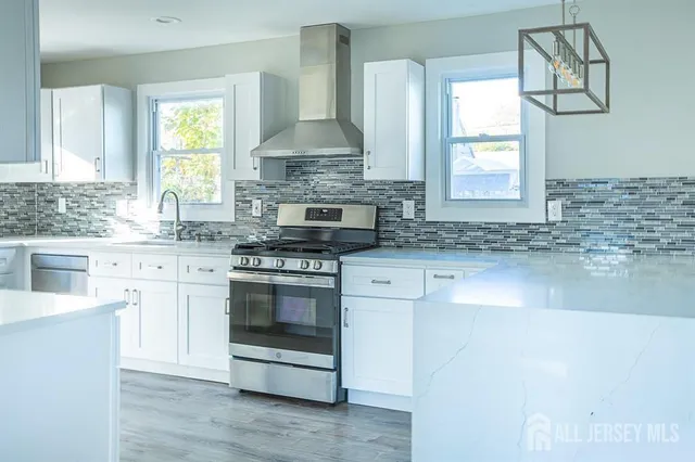 a kitchen with stainless steel appliances granite countertop a sink stove and cabinets