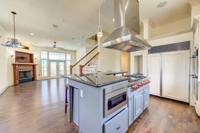 a kitchen with stainless steel appliances granite countertop a stove and a wooden floors