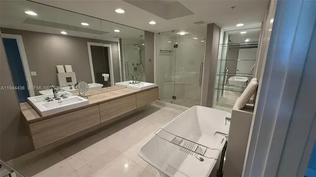 a bathroom with a double vanity sink a toilet mirror and shower