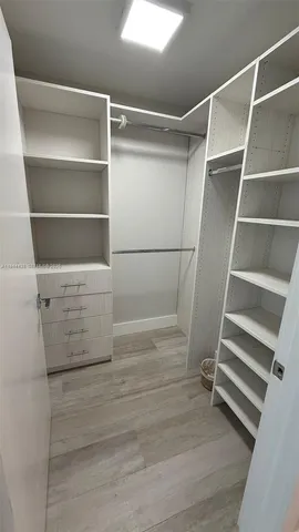 a view of walk in closet with empty racks