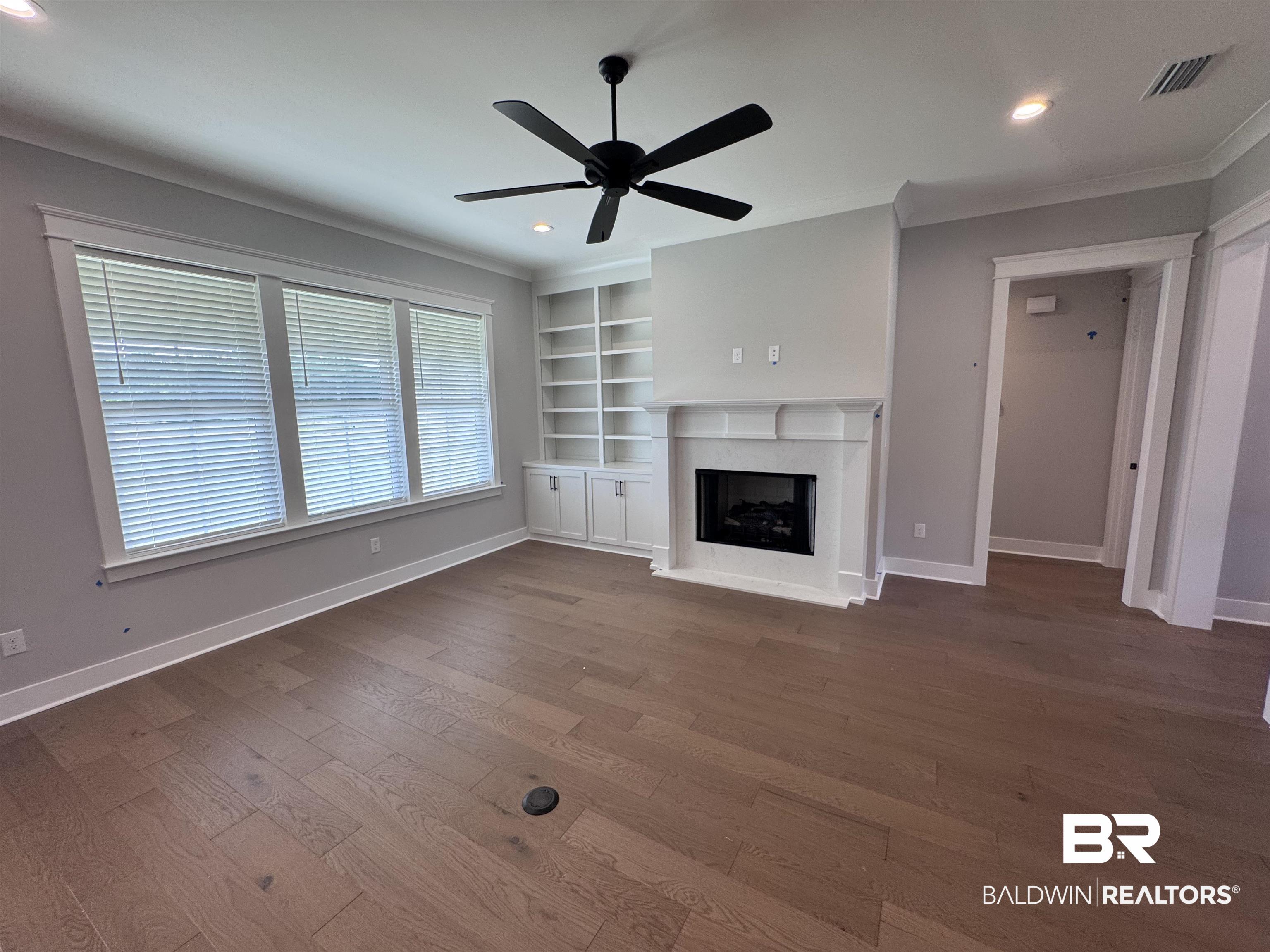 27371 Patch Pl Loop Daphne, AL 36526 - Photo 14 of 63 Unfurnished living room featuring built in shelves, recessed lighting, dark wood-type flooring, a ceiling fan, and a fireplace