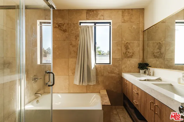 a bathroom with a tub sink and a mirror