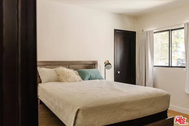 a bedroom with a bed and wooden floor