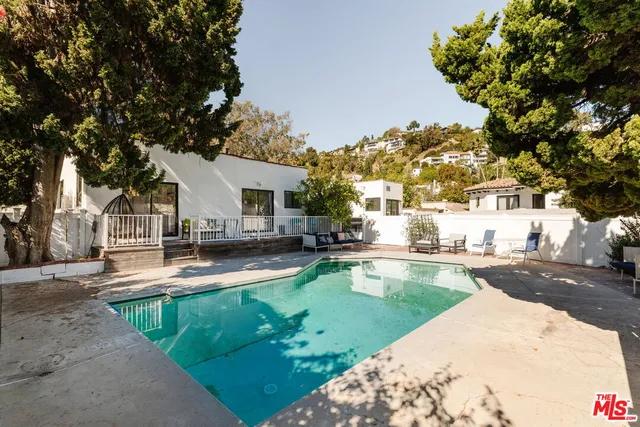 a view of a house with swimming pool and sitting area