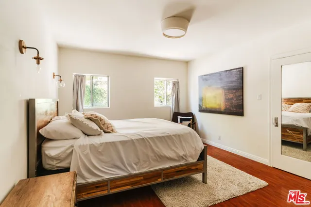 a bedroom with a bed and wooden floor