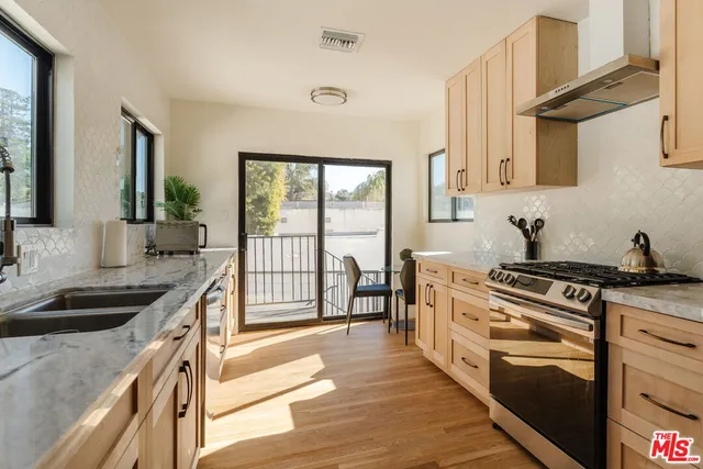 a kitchen with stainless steel appliances a stove sink and cabinets
