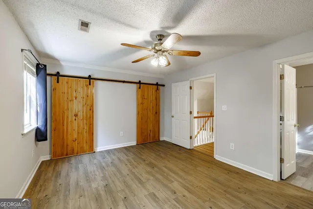 a view of a livingroom with a ceiling fan & hardwood floor