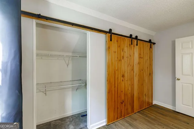 a view of walk in closet with wooden floor