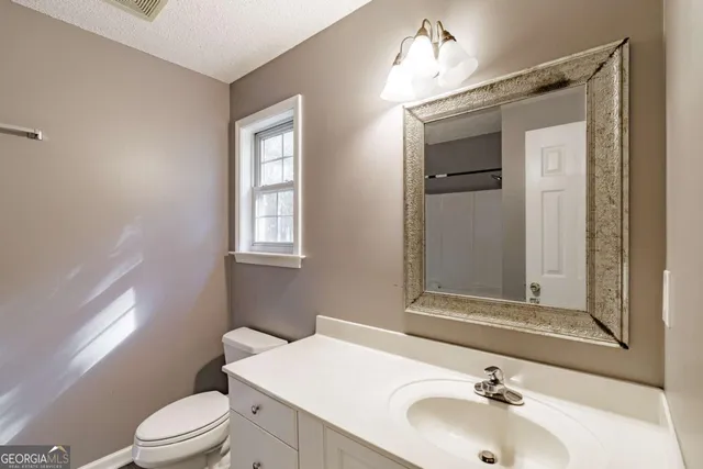 a bathroom with a sink vanity mirror and toilet