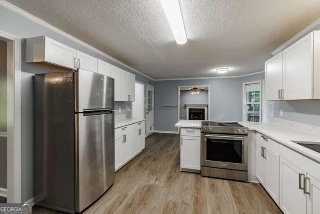 a kitchen with stainless steel appliances granite countertop a refrigerator stove and sink