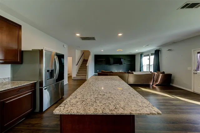 a kitchen with stainless steel appliances granite countertop a sink refrigerator and microwave