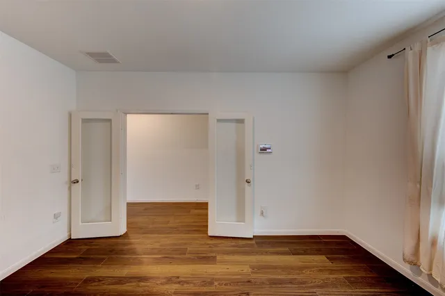 a view of an empty room with wooden floor