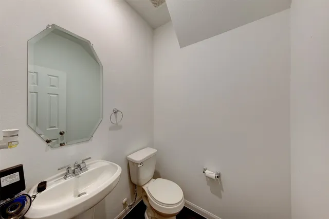 a bathroom with a toilet a sink and mirror