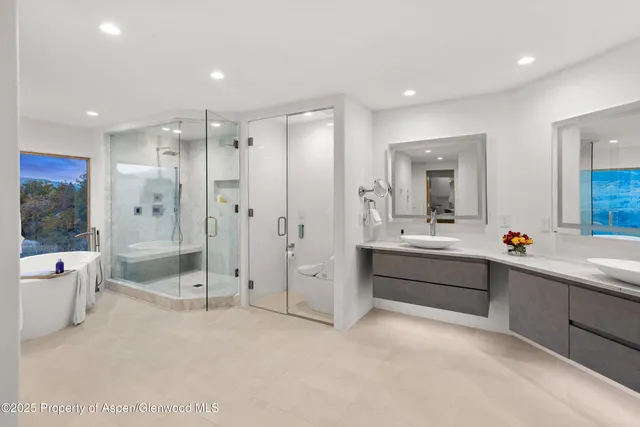 a large bathroom with a tub sink shower and mirror
