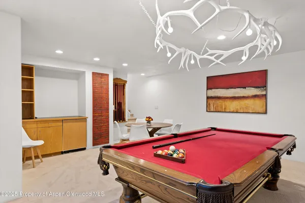 a room with pool table and a chandelier