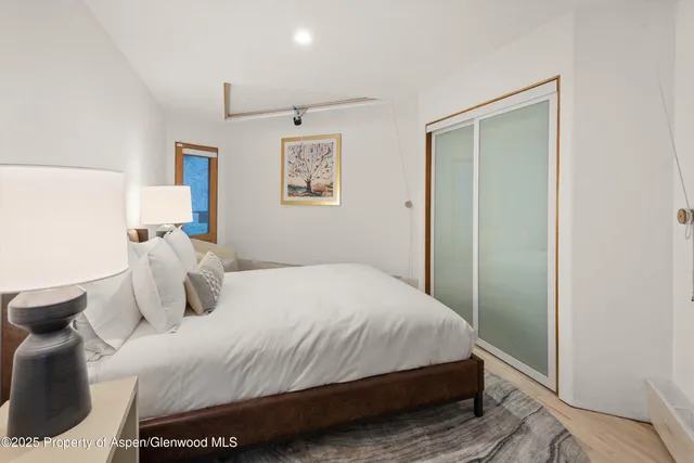 a bedroom with a bed and a painting on the wall