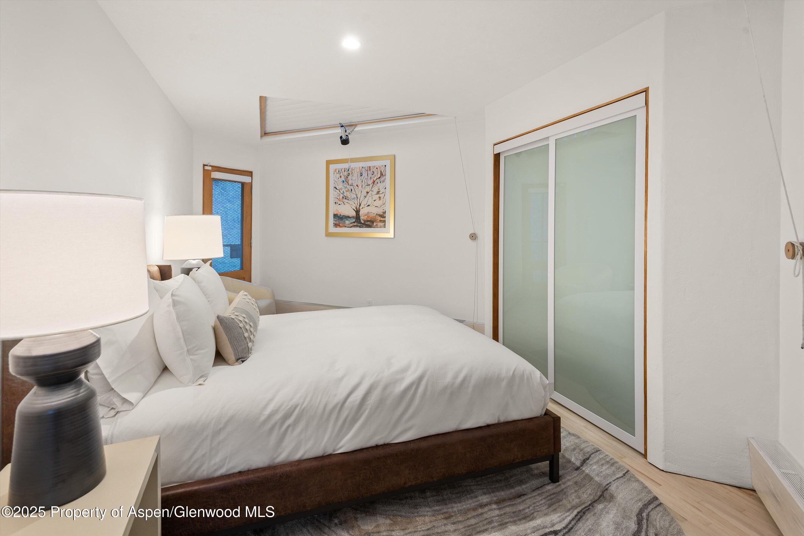 699 Eppley Drive Aspen, CO 81612 - Photo 28 of 45 a bedroom with a bed and a painting on the wall