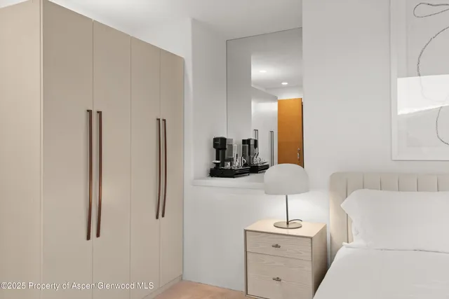 a room with a sink a lamp and a mirror