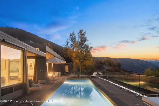 a view of a house with swimming pool and sitting area